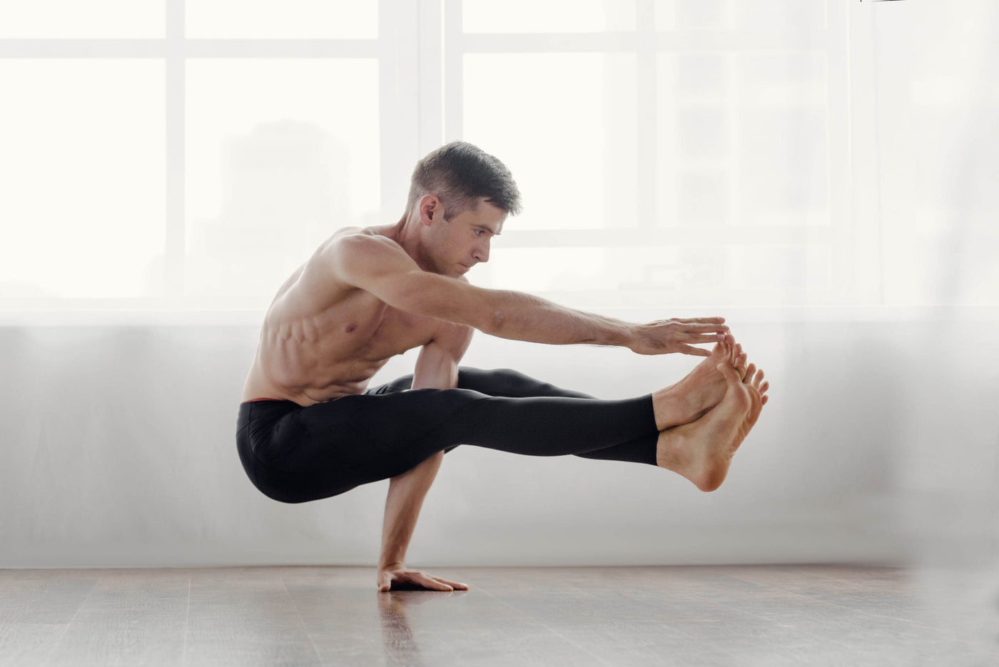 Strong man doing a difficult yoga pose | Asana Singapore - The Ultimate Workout Mats