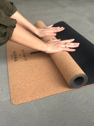 Woman's Hand Demonstrating Thin Material Design And Rolling Of The Cork TR Travel Yoga Mat by Asana Singapore
