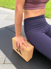Woman in blue athleisure wear propping herself with The Cork Block Set by Asana Singapore